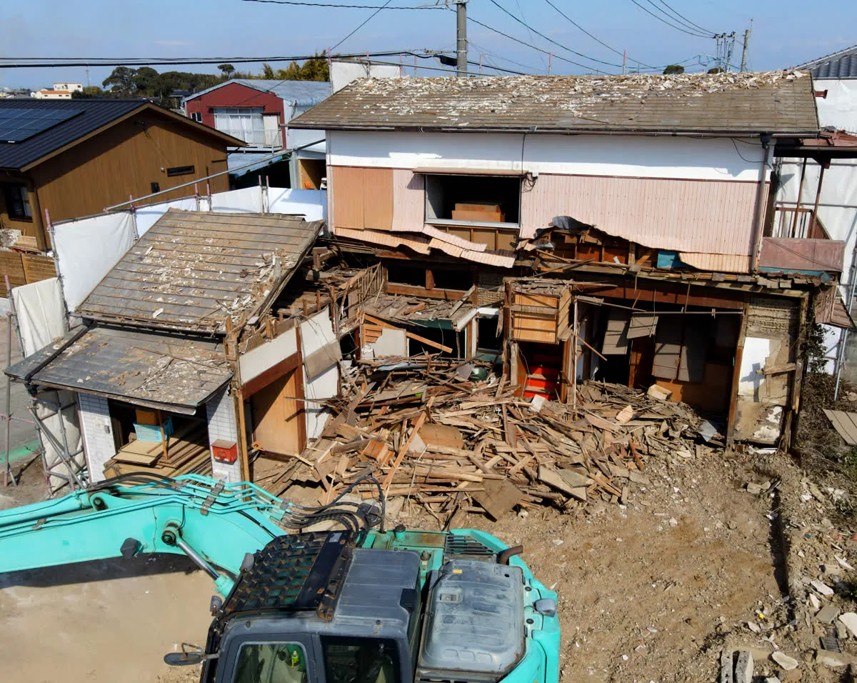 重機で老朽化した木造住宅を解体する様子