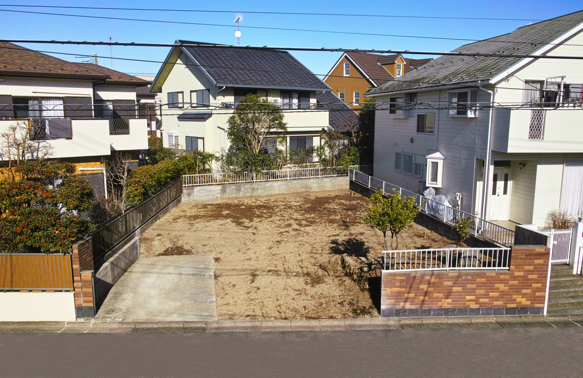 住宅街の解体後の更地。道路側の塀と門まわりが残っている