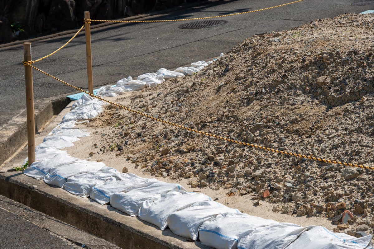 道路側に土のうを並べた解体後の更地